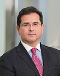 Pablo Carrillo, a man with dark hair wearing a dark suit and red tie.