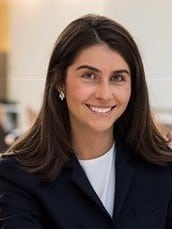 Lauren Stimpert, a dark haired woman wearing a dark jacket and white shirt.